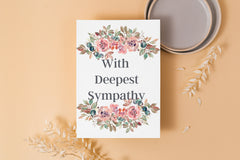 Floral card saying, With deepest sympathy sitting on peach table with dry leaves in background