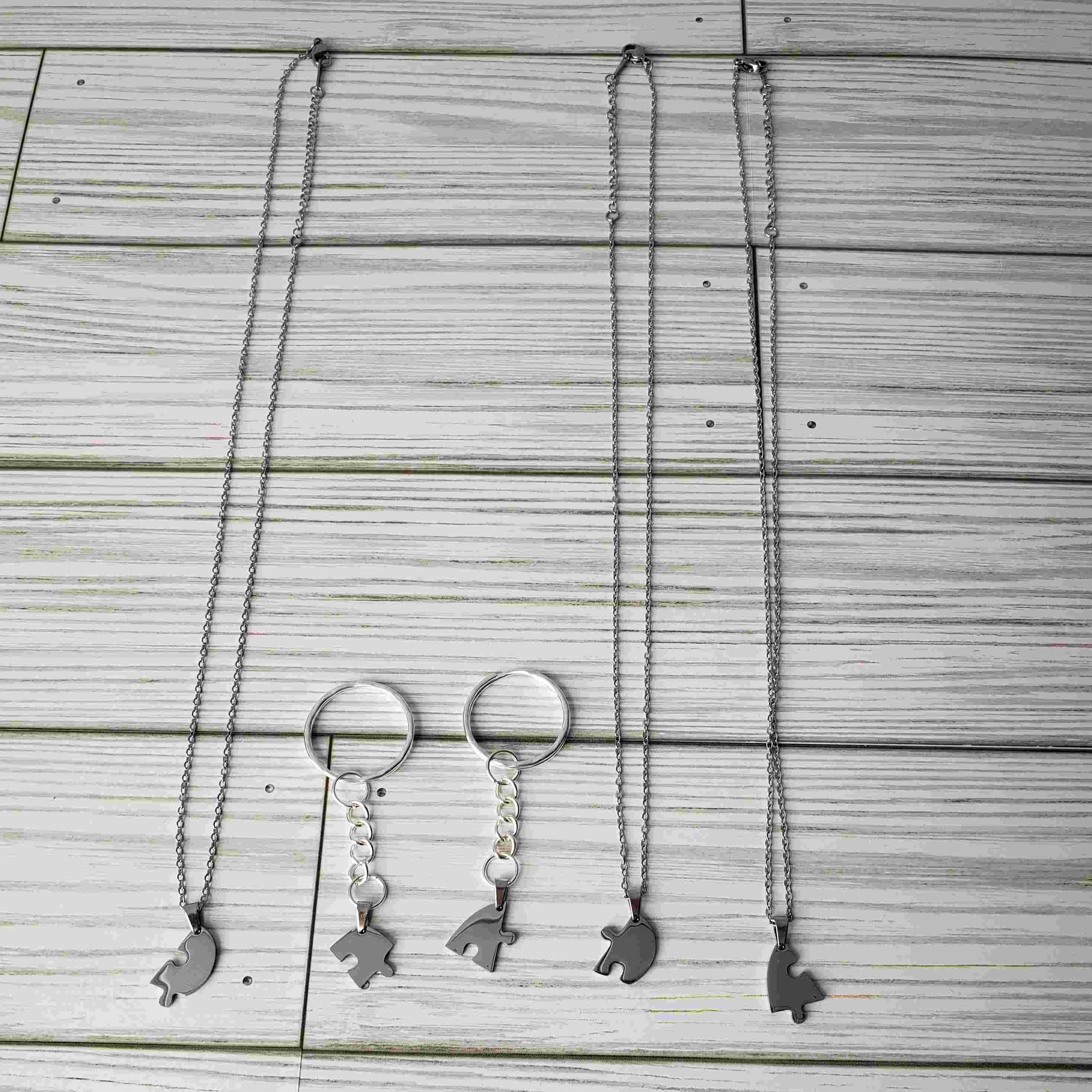 5-piece necklace set with 2 on key rings and 3 on chains laying on a table